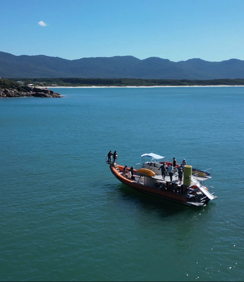 Barco Borrachão parado em águas cristalinas perto da costa da Barra da Lagoa em Florianópolis.